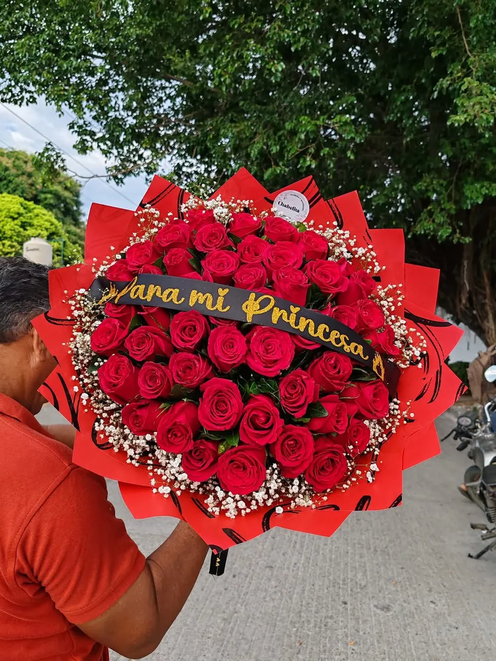 Entrega de un ramo de rosas rojas con banda dorada Para mi princesa