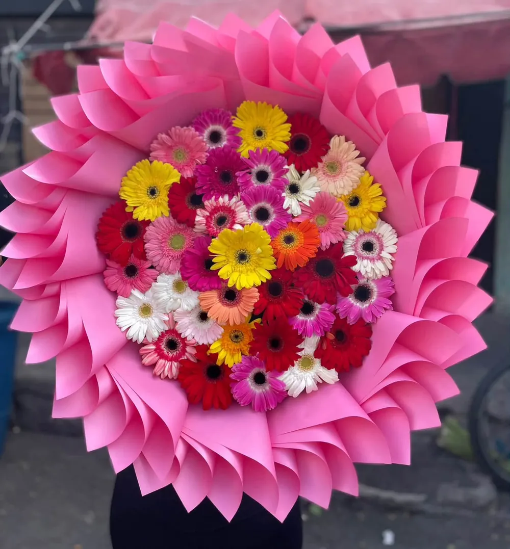 Ramo Gerberas Arcoíris: gerberas de colores en un espiral de papel rosa
