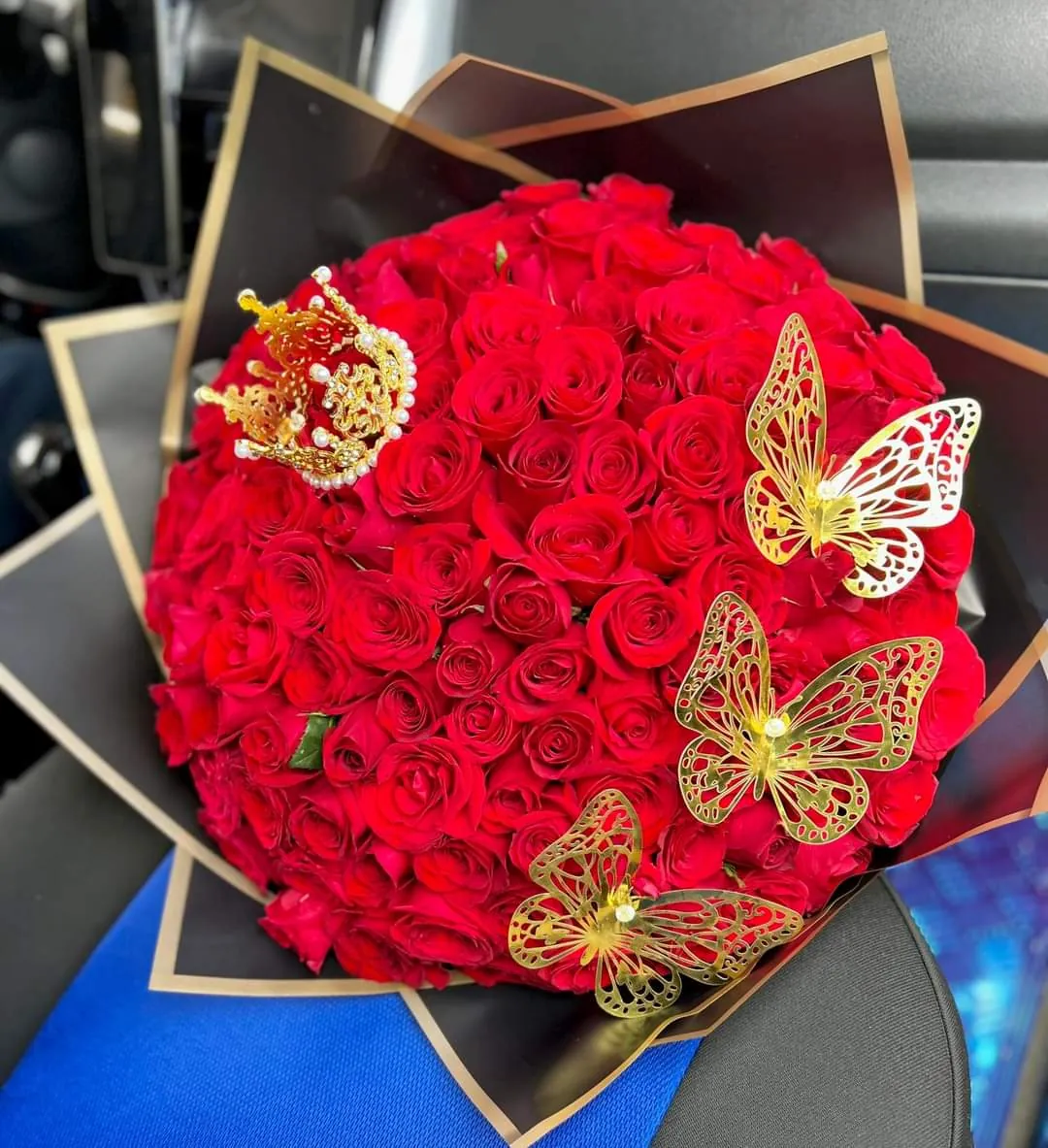 Ramo de cientos de rosas rojas con mariposas doradas y corona